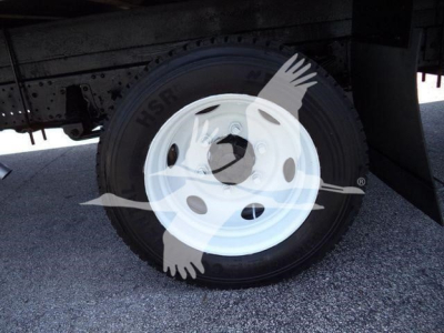 Isuzu NPR HD truck wheel and fender area showing white steel wheel and tire undercarriage.