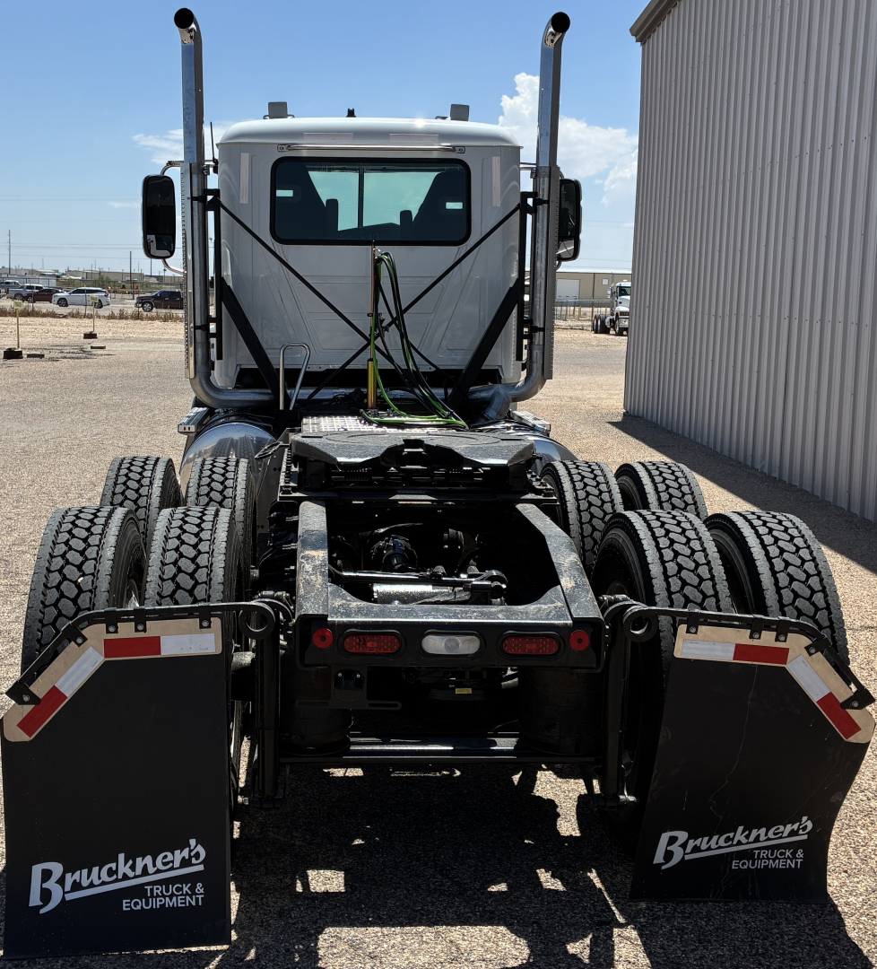 Rear view of a 2027 Mack PI64T conventional daycab truck showing dual rear axles, fifth wheel, and mudflaps with Bruckners Truck & Equipment logos.