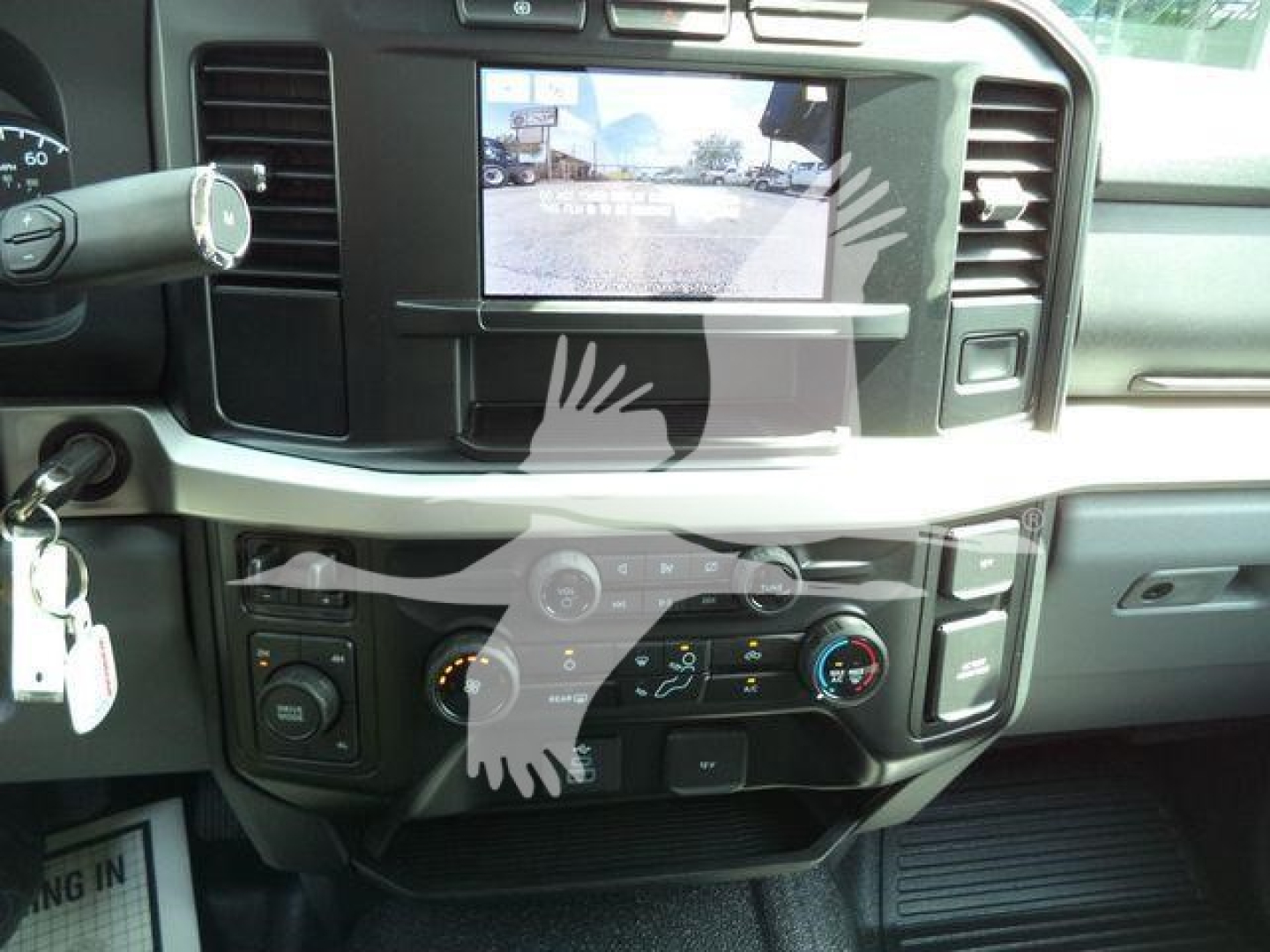 Ford F-450 interior dashboard with center touchscreen display and climate controls, stock keys on the ignition, front cabin view.