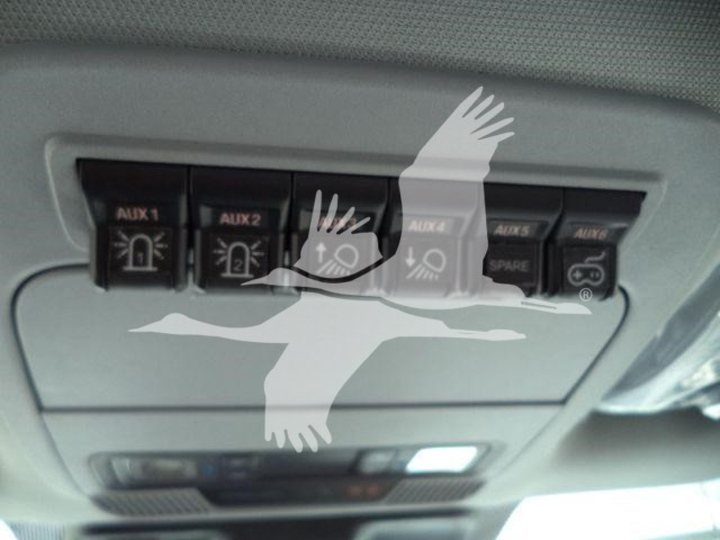 Ford F-450 overhead console showing auxiliary switches labeled AUX 1 AUX 2 AUX 3 AUX 4 with icons.