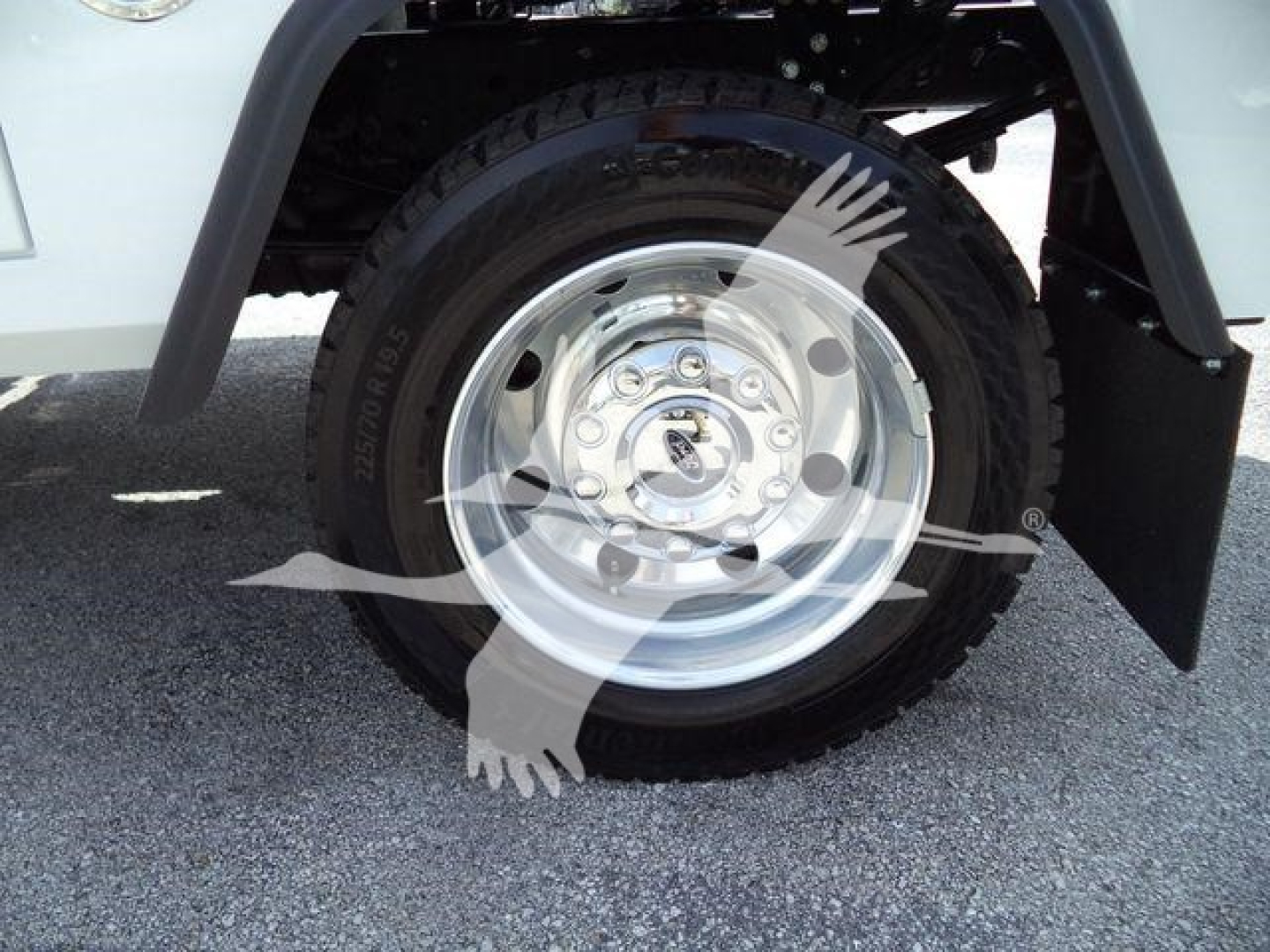 Ford F-450 wheel and tire assembly inview showing steel rim and tire under fender; winch category listing context visible.