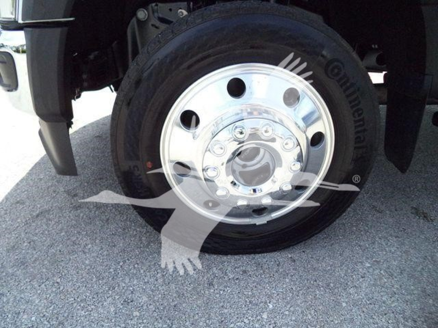 Wheel close-up showing steel polished hub and tire on Ford F-450 truck front wheel with chrome center hub.