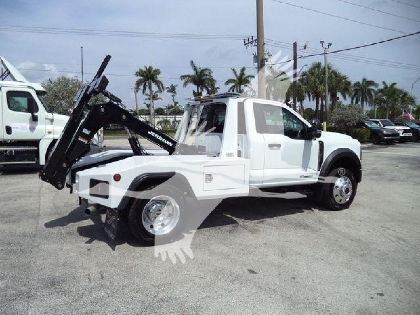 Tow truck side view showing SNATCH-WARNER style hydraulic wench and flatbed mechanism on a white Ford F-450 in-service; Winch category, labelless but visible components.
