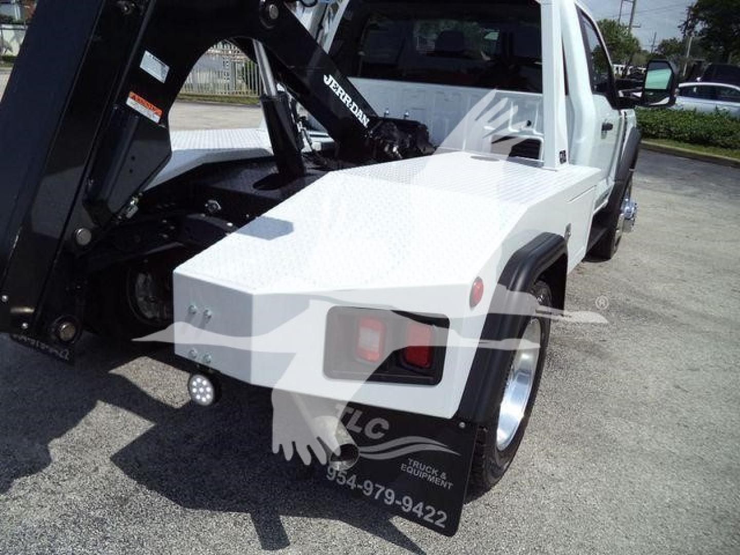 Ford F-450 tow truck with a mounted winch and flat black Crane arm visible on truck bed side.