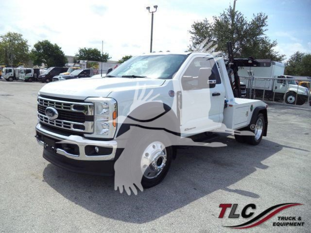 Ford F-450 tow truck front-left view with chrome grille and flatbed, blank background lot.