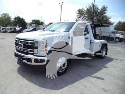 Ford F-450 tow truck in a parking lot, front-left view, white with chrome bumper and grille, winch equipment on bed, stock number J40065FM.