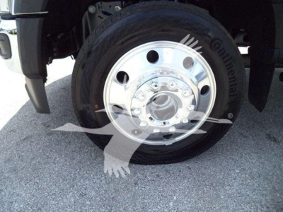 Wheel close-up showing steel polished hub and tire on Ford F-450 truck front wheel with chrome center hub.