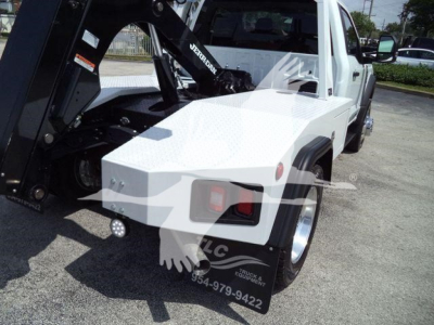 Ford F-450 tow truck with a mounted winch and flat black Crane arm visible on truck bed side.