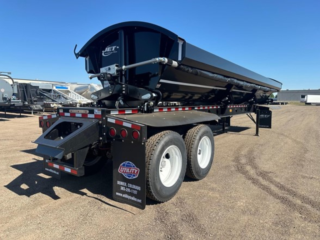 Dump trailer with dual rear axles and a raised bed showing Jet pivot points and tub corners; side rails and rear hydraulic components visible.