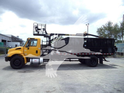 Vehicle side view of a 2019 International 4300 grapple truck, yellow cab with black grapple bed and hydraulic equipment extending over the cab.