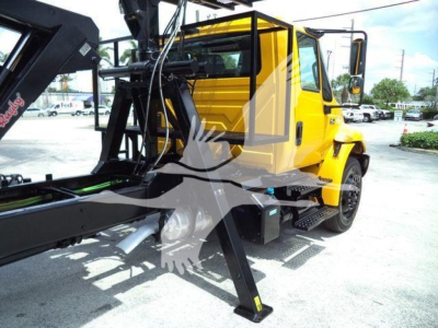 2019 International 4300 with grapple truck body showing yellow cab and hydraulic grapple attachment.