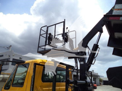 Truck cab with a yellow body and a raised grapple crane attachment mounting station visible in side view.
