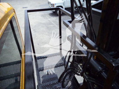 Truck cabin and forklift-like grapple attachment on 2019 International 4300, interior view of operator area and control frame.