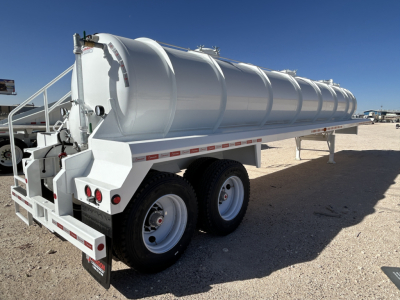 Vacuum trailer showing a long cylindrical stainless steel tank on a dual-axle trailer with rear lights and ladder. No visible text on the tank or chassis.