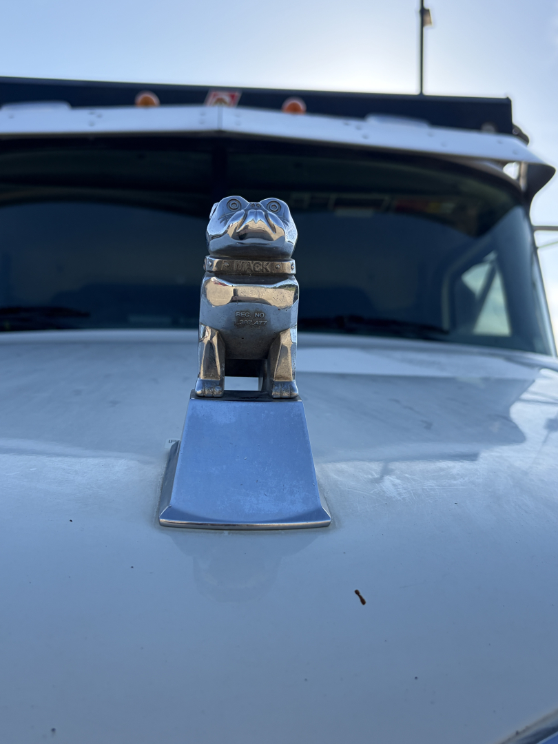 Mack hood ornament on truck showing chrome mascot and windshield in background