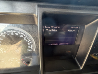 Truck cab dash showing instrument cluster and digital display with odometer and date. Visible text includes Total Miles 139520.1 and chassis ID on screen.