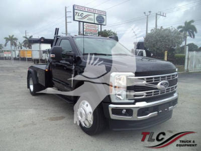 Ford F-450 truck in a dealership lot, black, with chrome grille and front bumper; winch category listed on sign in background.
