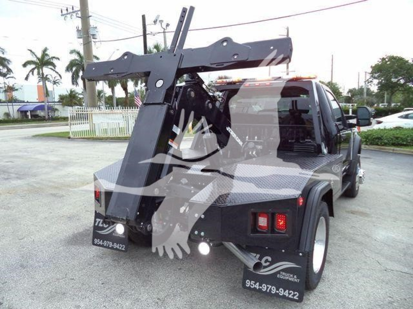 Rear view of a 2024 Ford F450 tow truck with a heavy-duty winch and hoist system mounted on the bed, showing winch apparatus, crane-like frame, and towing equipment.