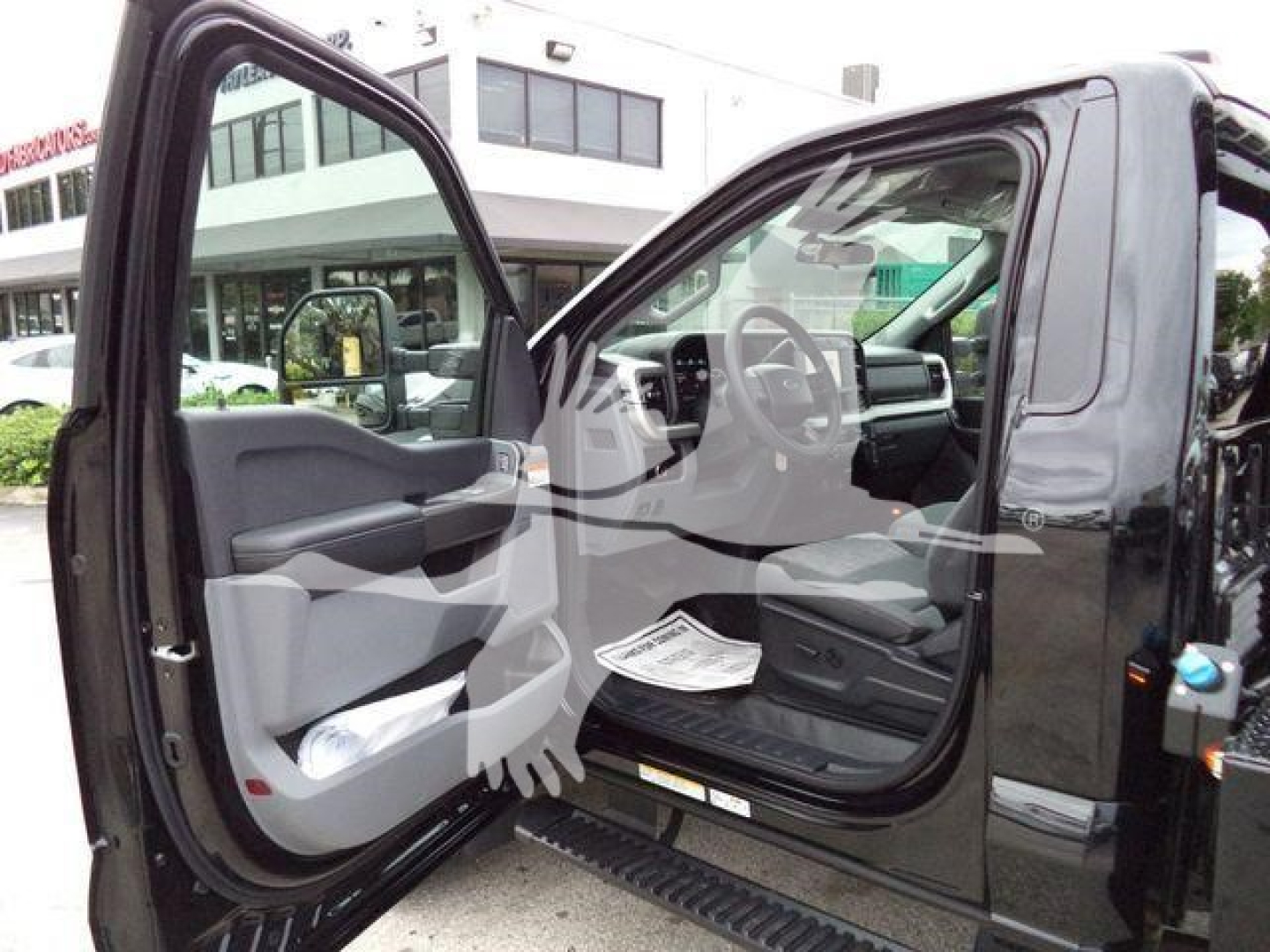 Ford F-450 cab interior with open driver door showing steering wheel, dashboard, and seating area.