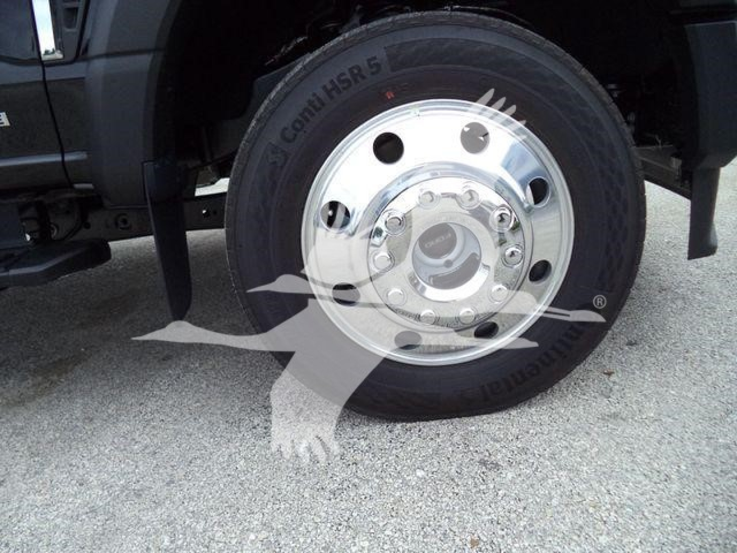 Front wheel of a 2024 Ford F450 with chrome hub and Conti HSR tire; partial vehicle fender and suspension visible.