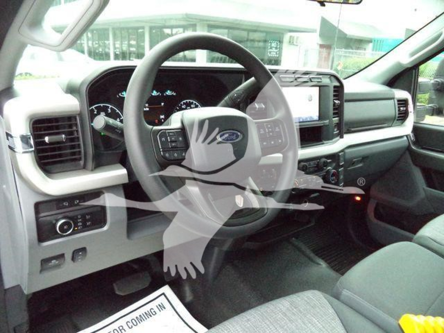 Interior of a Ford F-450 truck cabin showing steering wheel, dashboard, large touchscreen, and driver's seat.