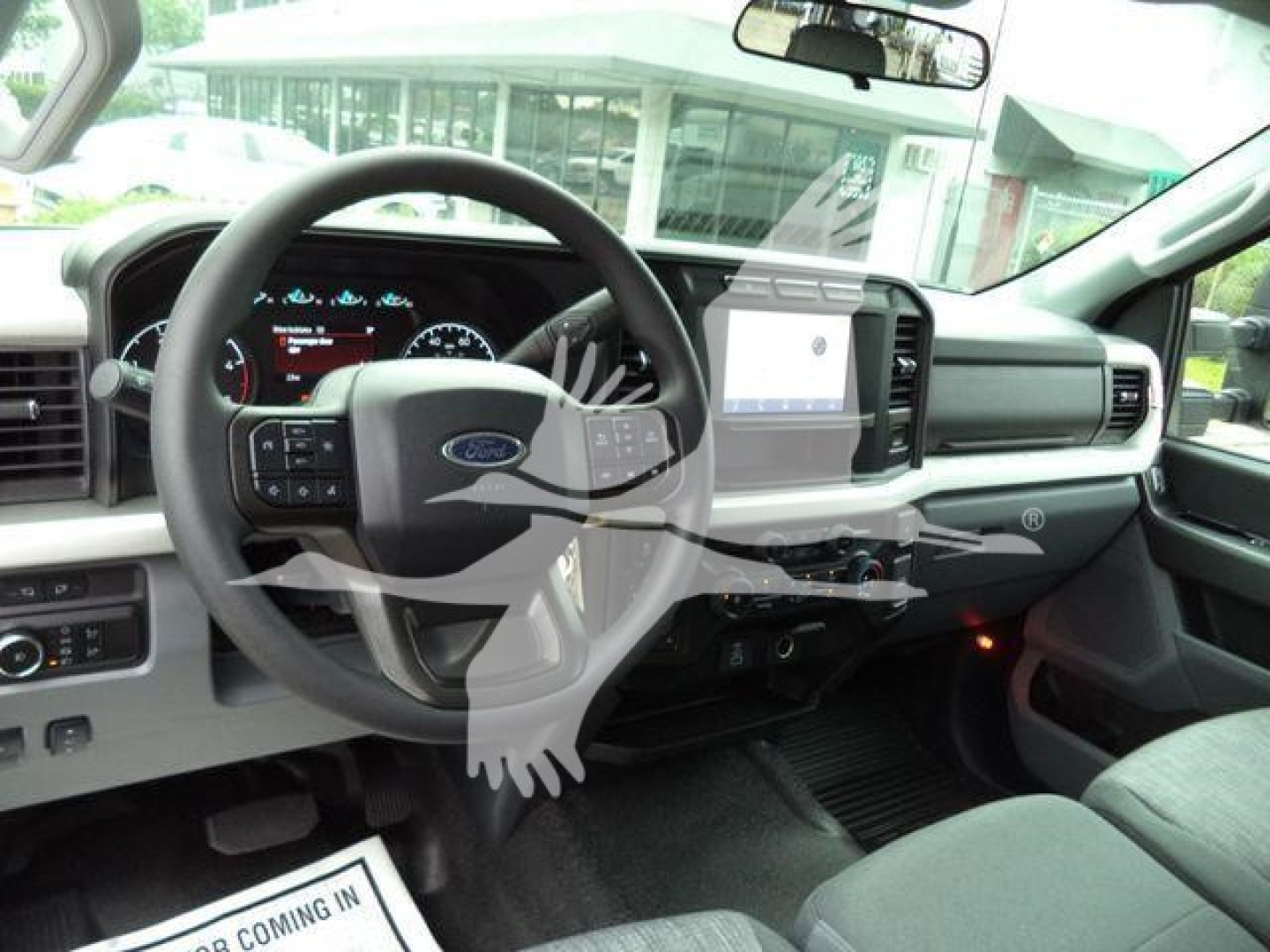 Interior of a 2024 Ford F-450 pickup showcasing steering wheel with Ford emblem, digital instrument cluster, and center console with large touchscreen display.