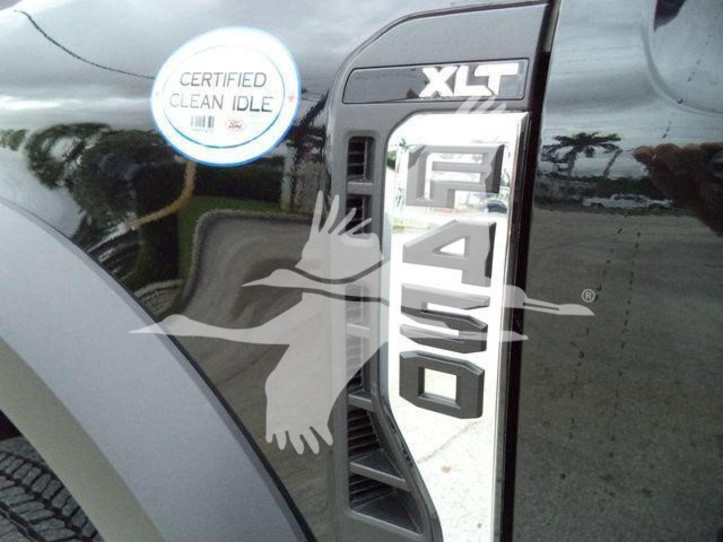 Ford F-450 Super Duty XLT badge on black truck fender with 'Certified Clean Idle' sticker visible.