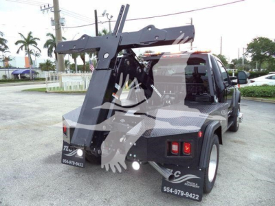 Rear view of a 2024 Ford F450 tow truck with a heavy-duty winch and hoist system mounted on the bed, showing winch apparatus, crane-like frame, and towing equipment.