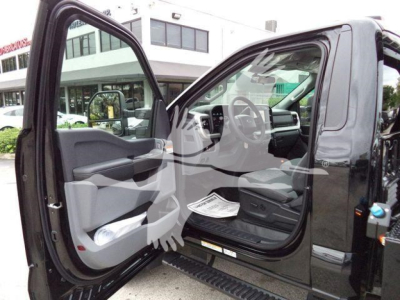 Ford F-450 cab interior with open driver door showing steering wheel, dashboard, and seating area.