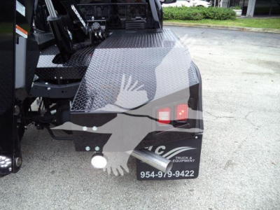 Rear/side view of a 2024 Ford F-450 winch-equipped truck bed with diamond plate flatbed and rear lighting, showing stock number J40067FM and contact number 954-919-9422.