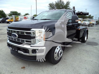Ford F-450 tow truck front-left view showing chrome grille and large dual rear wheels.