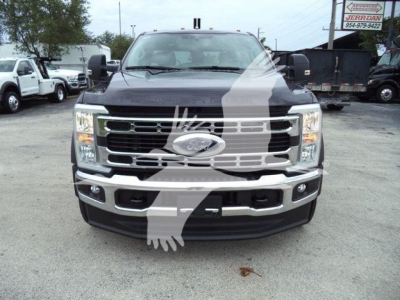 Front view of a 2024 Ford F-450 truck with large chrome grille, rectangular headlights, and bumper; dealer watermark overlay.