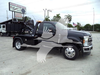 2024 Ford F450 tow truck with a stock wheelbase, black body, flatbed with hydraulic winch system, front chrome bumper, side mirrors, and branding visible in lot.