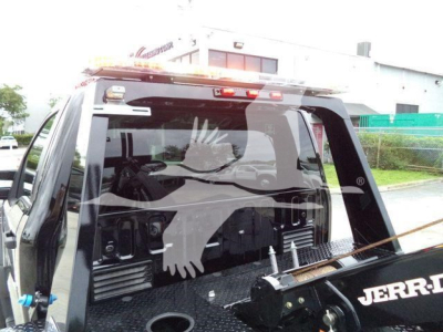 Ford F-450 pickup truck rear showing a winch setup with protective cage and JERR-DYNE branding on the winch.