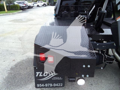 Rear view of a black metal toolbox on a Ford F-450 truck with TLC Truck & Equipment logo, phone number 954-979-9422, and two red/white lights.