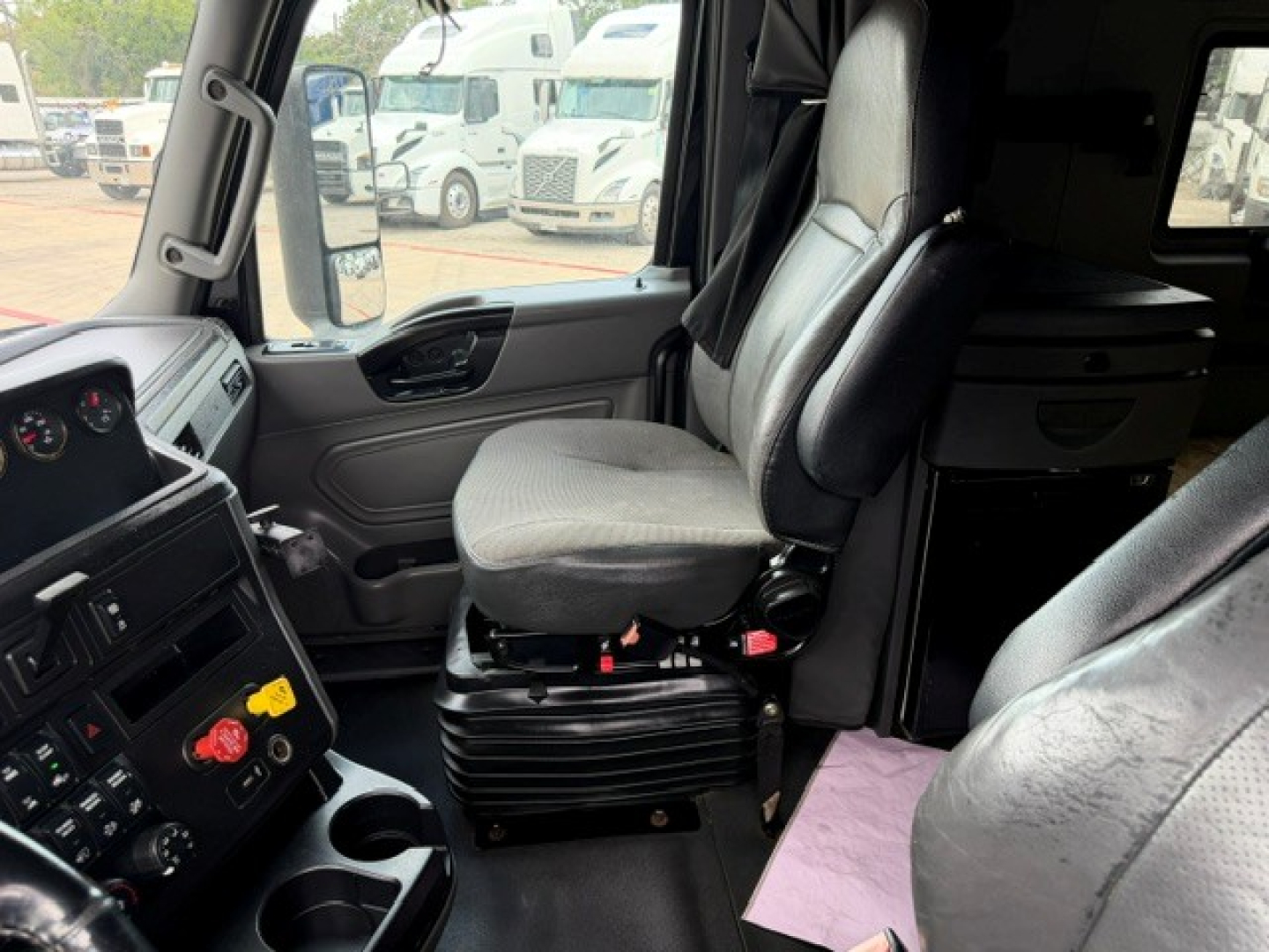 Interior of a 2022 International LT sleeper cab showing driver seat with surrounding dash and controls.