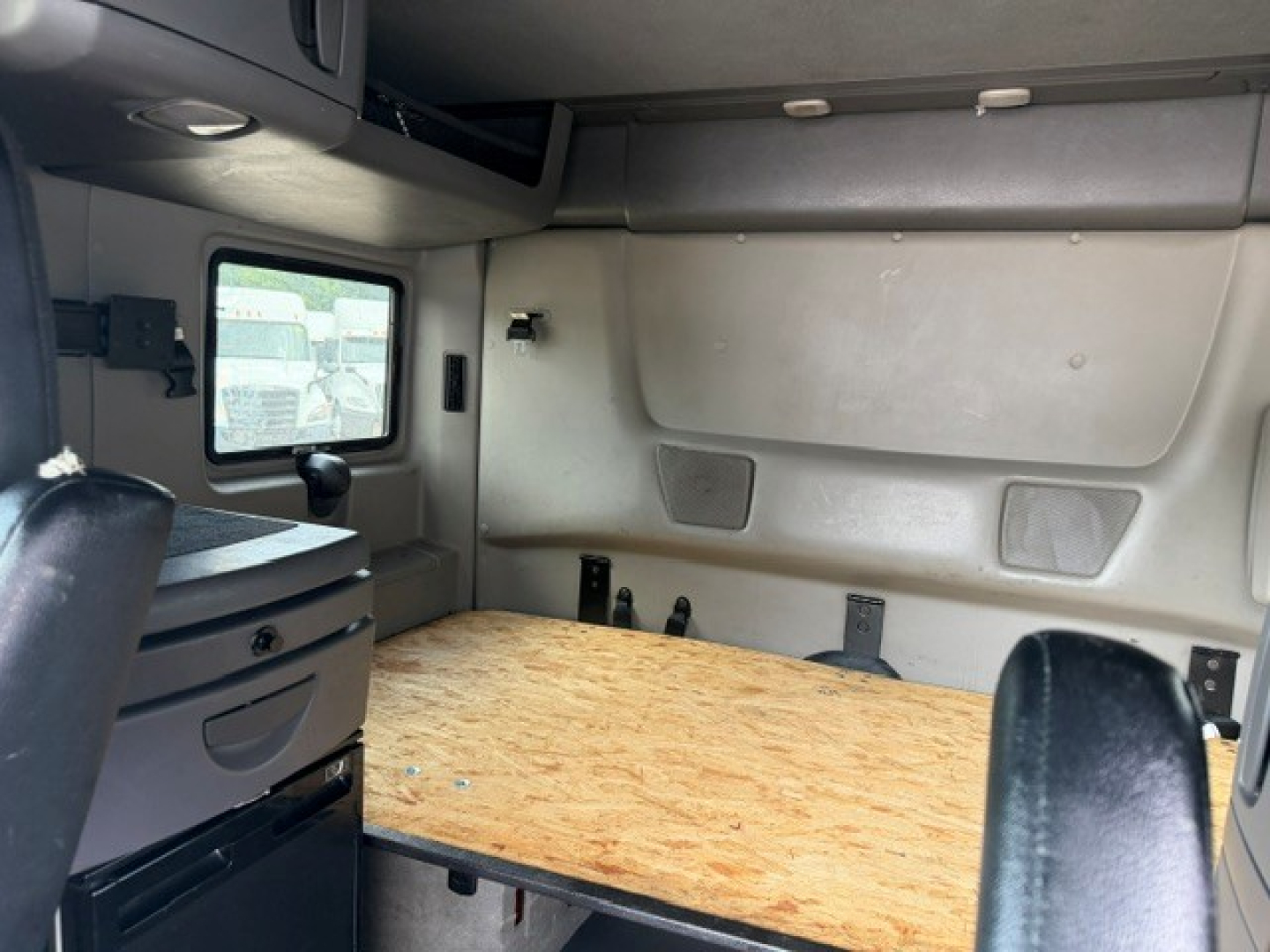 Interior sleeper cab cargo area of 2022 International LT showing plywood bed platform and wall panels.