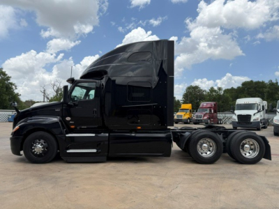 Truck chassis and cab visible side profile showing black International LT sleeper, dual rear axles, and side steps.