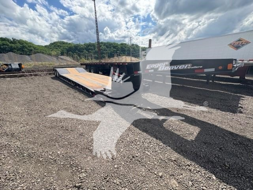 Lowboy trailer in a yard showing Eager Beaver 35Gsl-Pt branding on side and loading ramp extended.