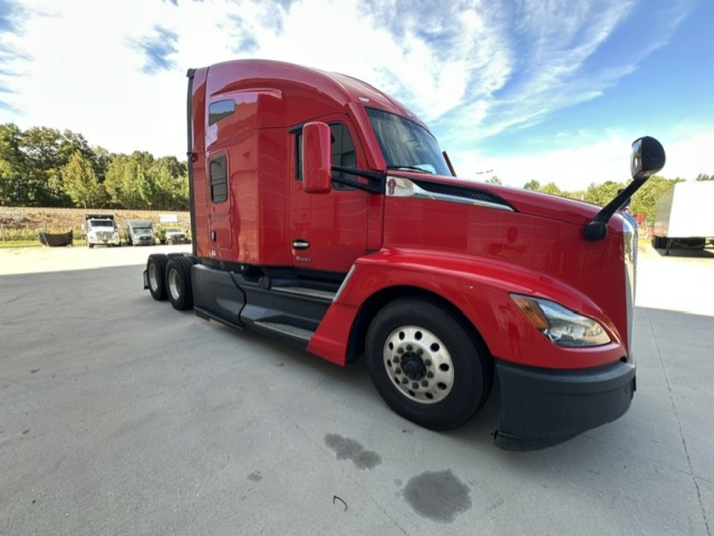 Kenworth T680 sleeper tractor in red, side view showing front grille, hood, and cab with large side mirror.