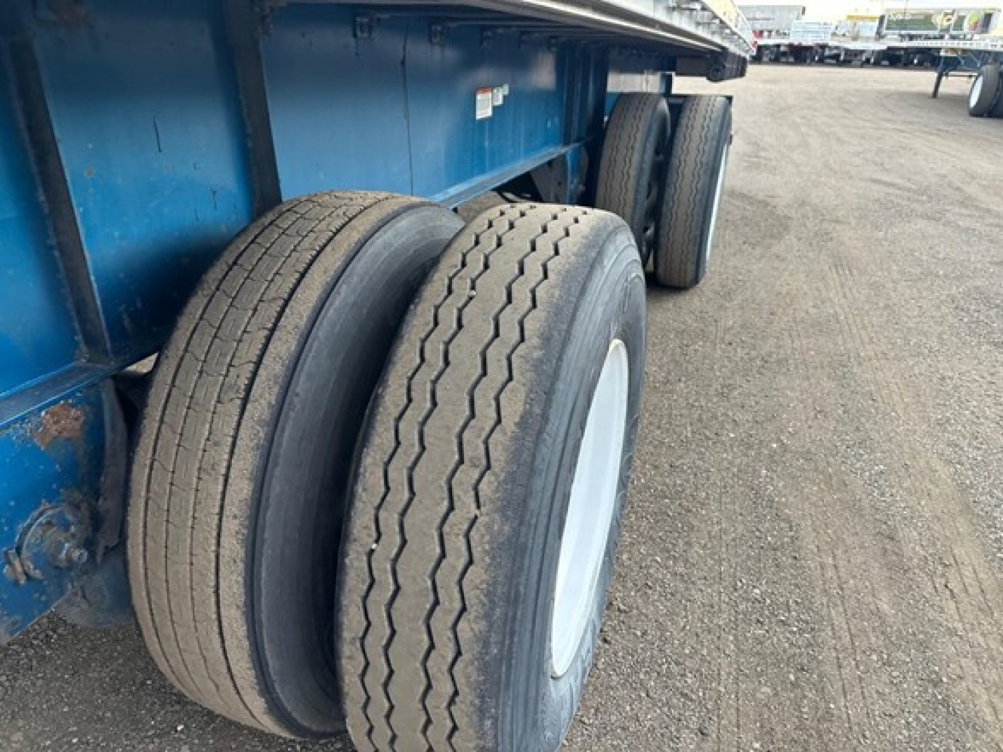 Great Dane trailer wheel assembly showing dual rear tires and blue frame.
