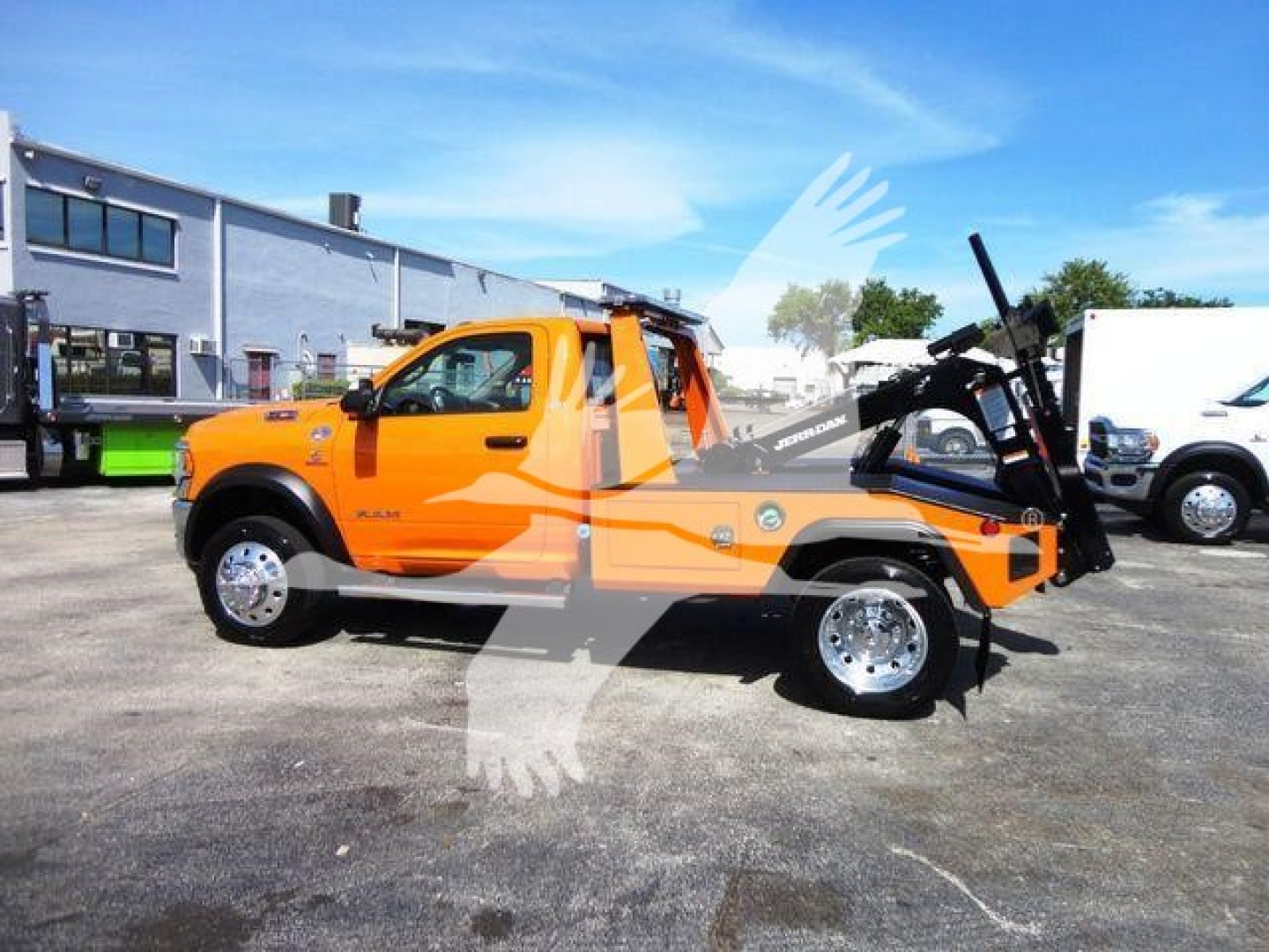 Orange 2024 Ram 4500 SLT pickup with winch attachment and hook, side view, stock number J70440, in a dealership lot.