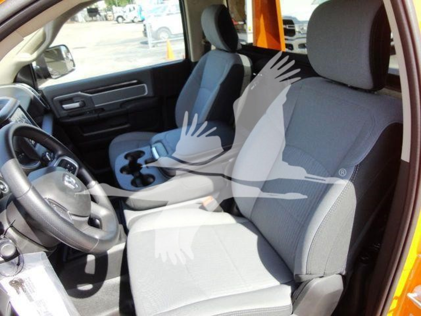 Ram 4500 interior view showing front seats, steering wheel, center console; light-gray cloth seats and black interior trim.