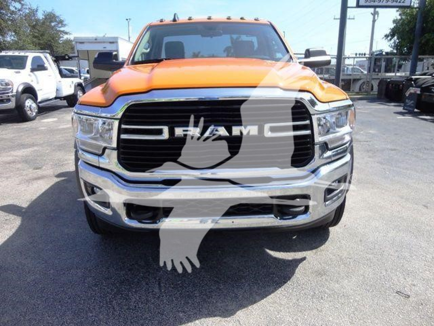 Ram 4500 SLT front view showing chrome grille and orange hood in a truck lot.