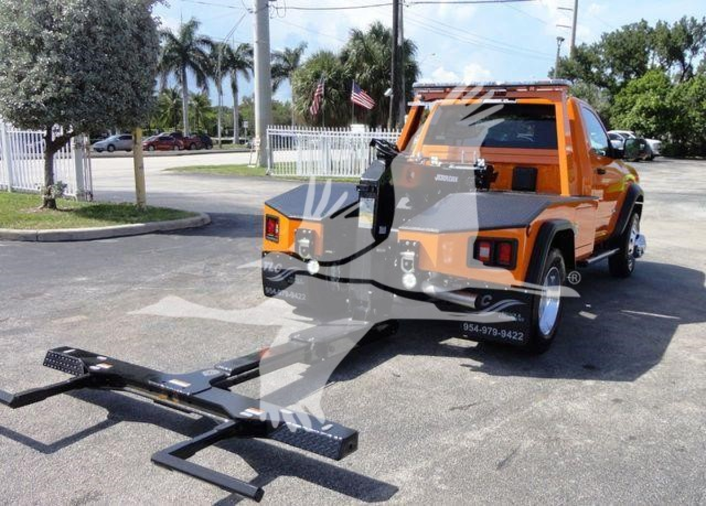 Truck with yellow/orange Ram 4500 SLT pickup hitch and winch attachment in foreground