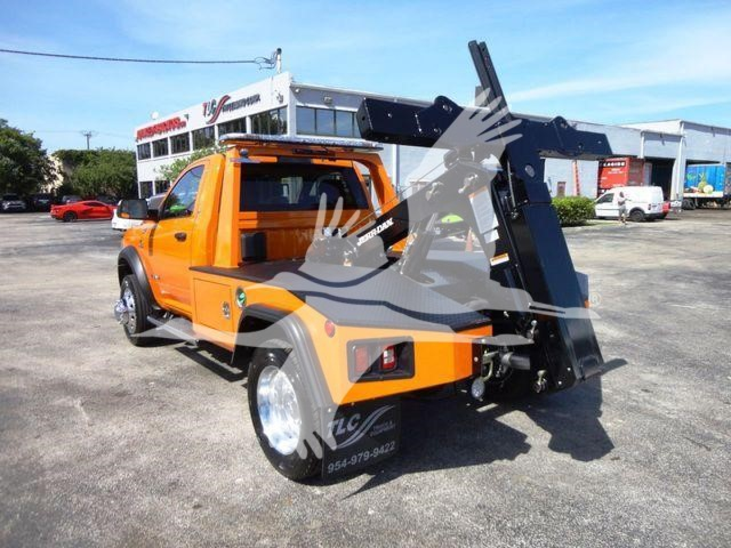 Orange Ram 4500 pickup with a hydraulic winch in rear, side view showing winch cradle and rear bumper.