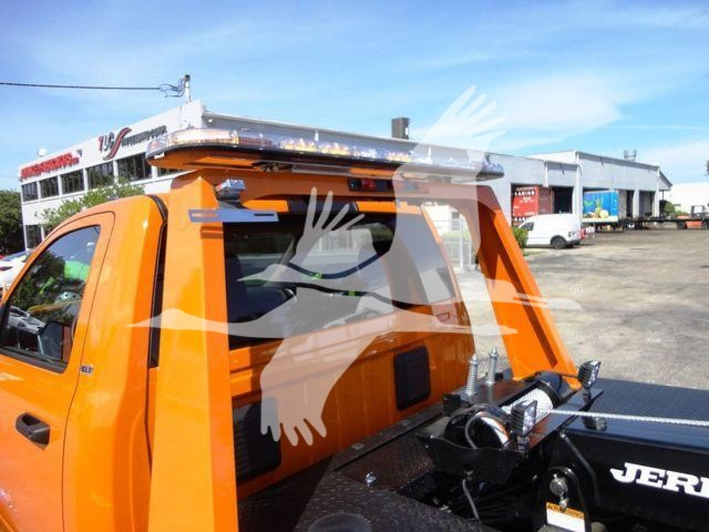 Ram 4500 pickup with winch setup and roof rack in cargo bed, orange cab, side view showing winch components and rack rails.