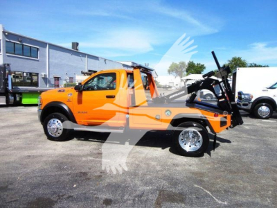 Orange 2024 Ram 4500 SLT pickup with winch attachment and hook, side view, stock number J70440, in a dealership lot.