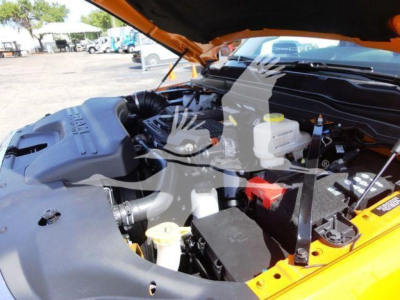 Ram 4500 engine bay with orange hood open showing air intake, coolant reservoir, and battery in view