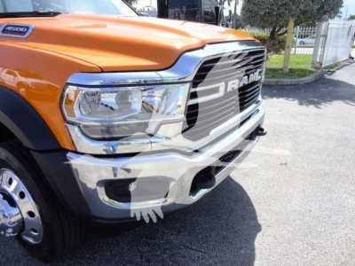Front-left view of a bright orange 2024 Ram 4500 with prominent chrome grille and bumper, showing the RAM badge and headlight assembly.